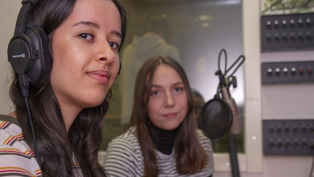 Två studenter vid kontrollbordet i en ljudstudio.