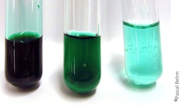 Bild på tre provrör med grön vätska i sig. Vätskan blir mer och mer genomskinlig, från vänster till höger.